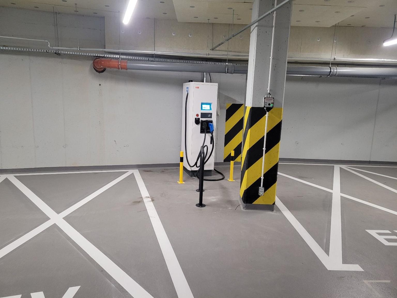 Stacja DC 50 kW w parkingu podziemnym biurowca i dedykowanymi miejscami parkingowymi dla najemcy